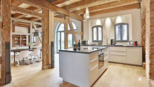A spacious kitchen with a large island, wooden beams, and modern appliances. - Backsteinspeicher Stralsund (Stralsund)