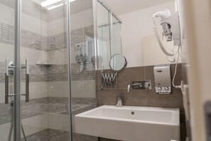 Habitación Confort con 1 cama matrimonial o 2 individuales, vista al jardín | Baño | Regadera, amenidades de baño gratuitas, secadora de cabello, bidet 