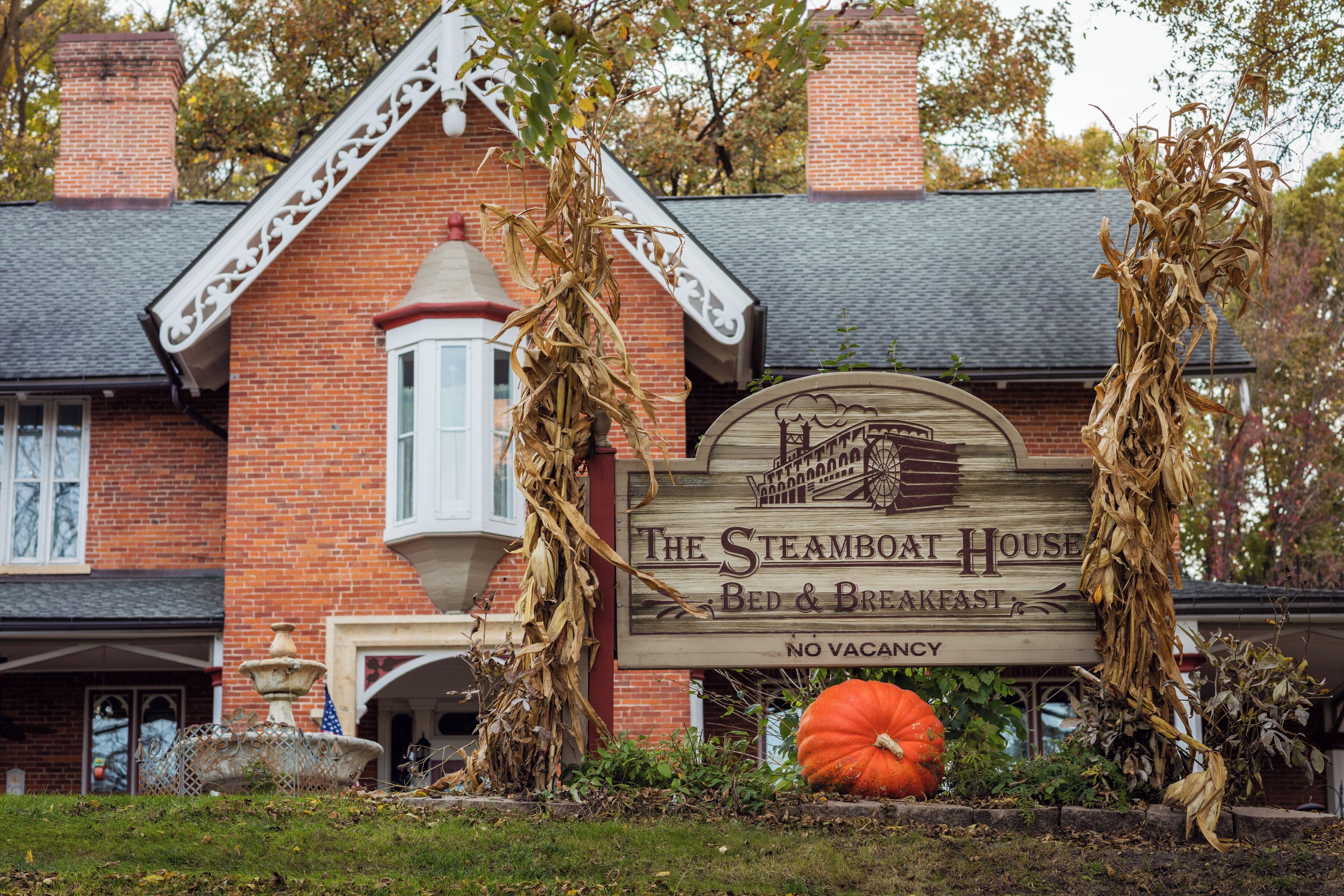 The Steamboat House Bed & Breakfast sign with a pumpkin and corn decoration.