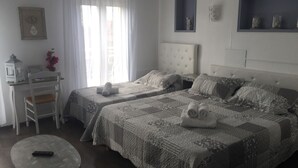 A hotel room with two beds, a desk, a chair, and a small table. - Luberon L'hôtel (Apt)