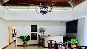 A spacious dining area with a high ceiling, a chandelier, and a mix of natural and artificial lighting. - Hotel Casa del Sol (Managua)