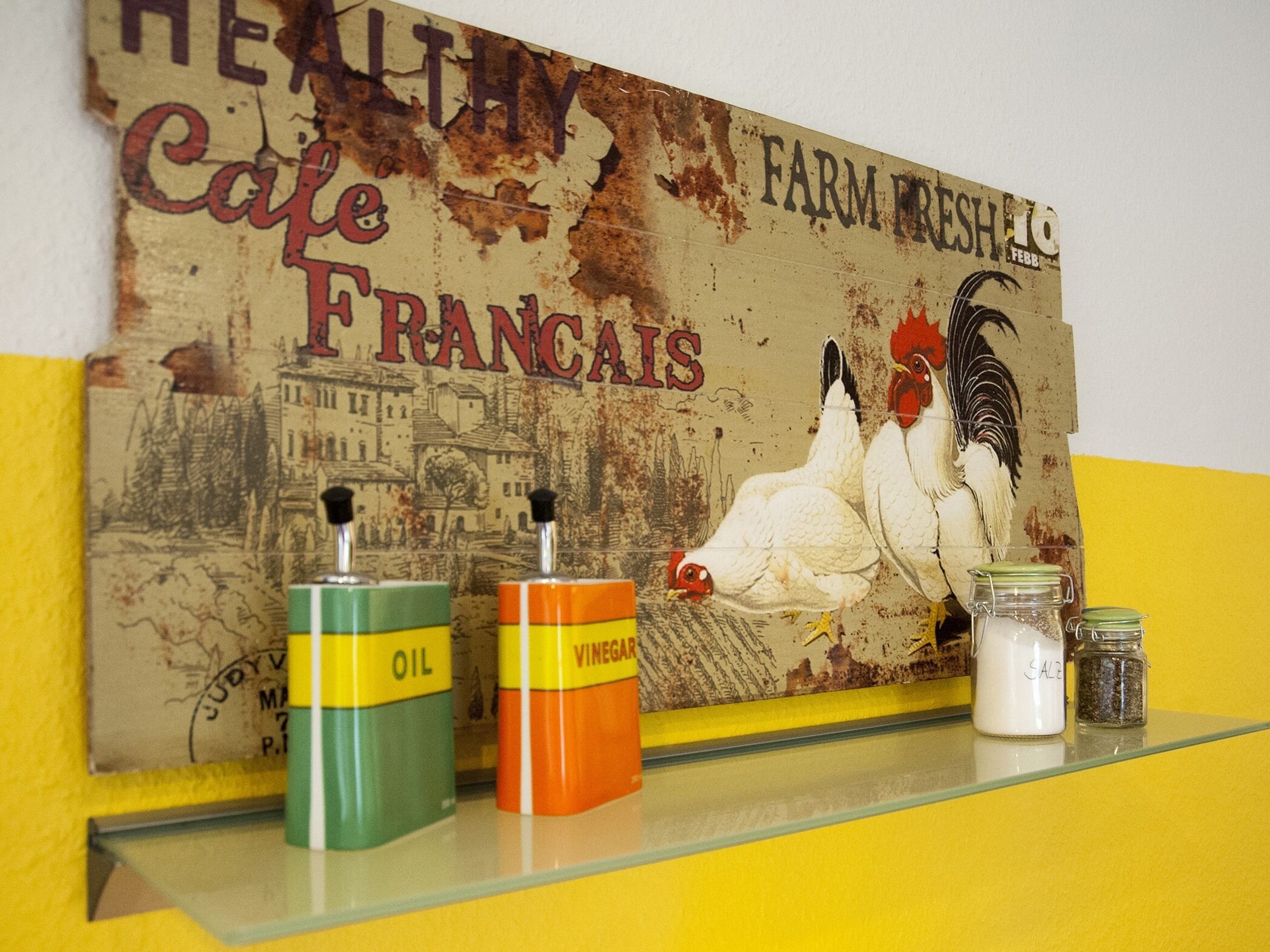 A wall with a vintage poster featuring chickens and the text "Healthy Cafe Francais Farm Fresh."