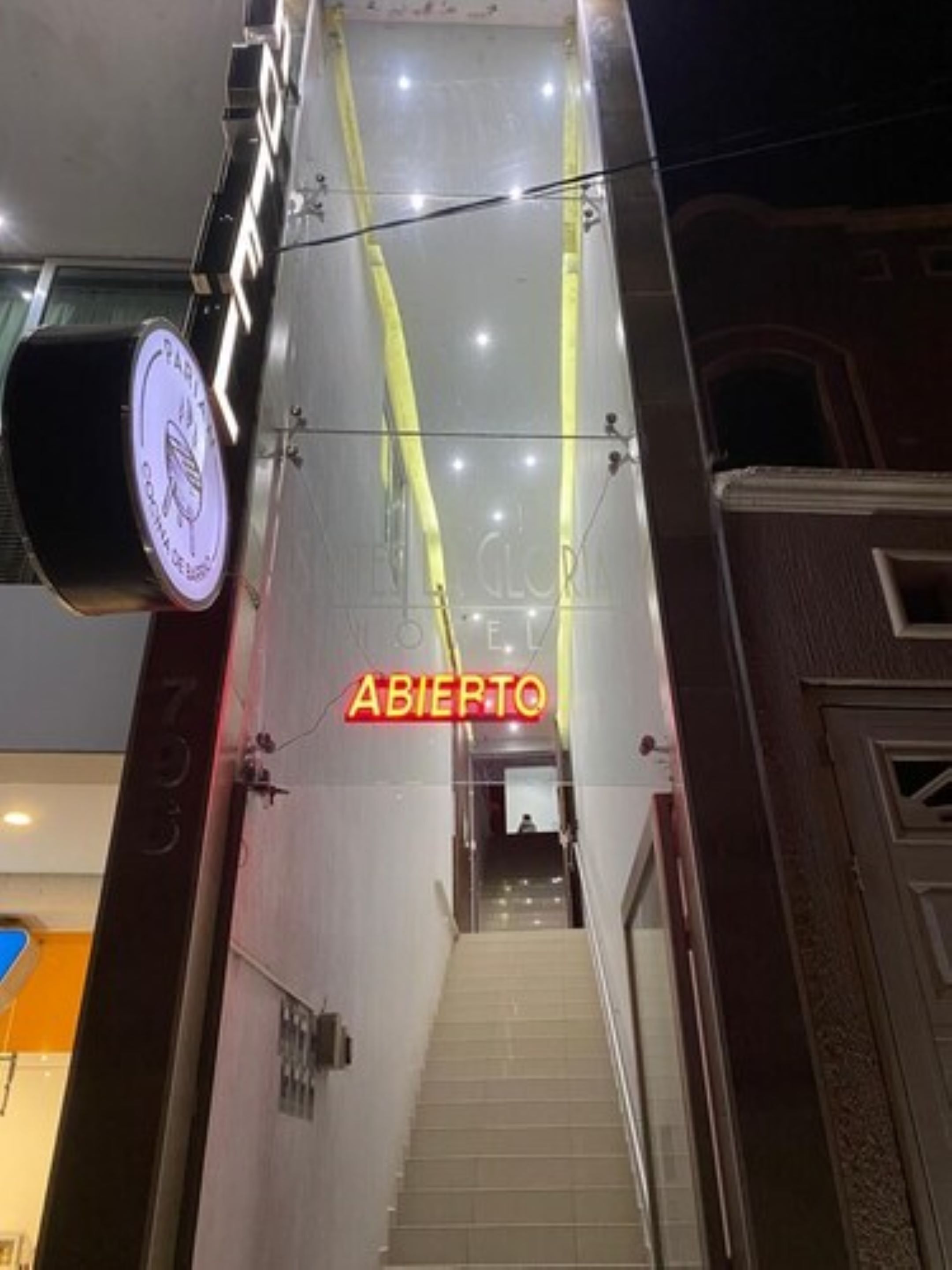 A hotel entrance with a sign reading "ABIERTO" and a logo above the door.