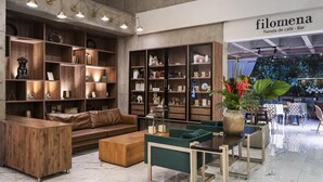 A modern interior with wooden shelves, a leather sofa, and a dining area with a table and chairs. - Hilton Garden Inn Cali Ciudad Jardin (Cali)