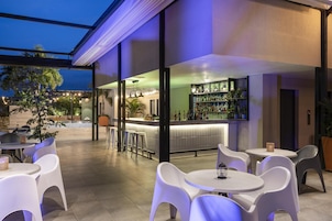 Un área de bar al aire libre con asientos y una barra.