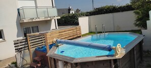 En rektangulär swimmingpool med ett trädäck, en stege och ett säkerhetsnät.