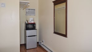 Una kitchenette compacta con refrigerador, microondas y cafetera.