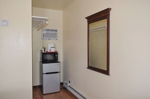 Uma cozinha compacta equipada com geladeira, micro-ondas e cafeteira.