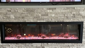 A rectangular stone wall with a built-in fireplace. - La Quinta Inn & Suites by Wyndham Opelika Auburn (Opelika)