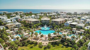 Een resort met een centraal gelegen zwembad, meerdere gebouwen en uitzicht op de oceaan.