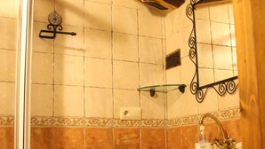 Une salle de bain avec une douche, un lavabo et un miroir.