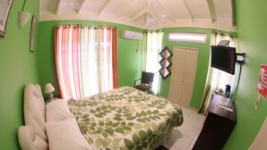 Une chambre à coucher avec un lit, un bureau, une chaise et un téléviseur.