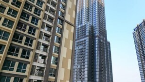A high-rise building with a modern glass facade, surrounded by other tall buildings.