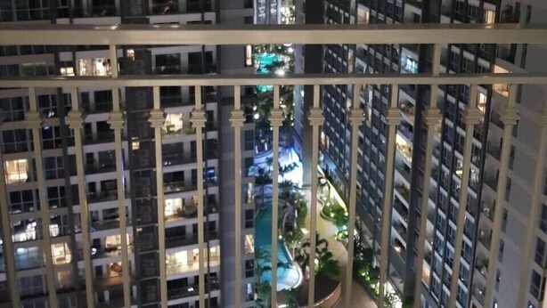A high-rise building with multiple floors, each with balconies. The building has a modern architectural design with a grid-like facade.