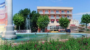 A hotel with a swimming pool, surrounded by greenery and a fountain. - Hotel Silvia (Castello d'Empuries)