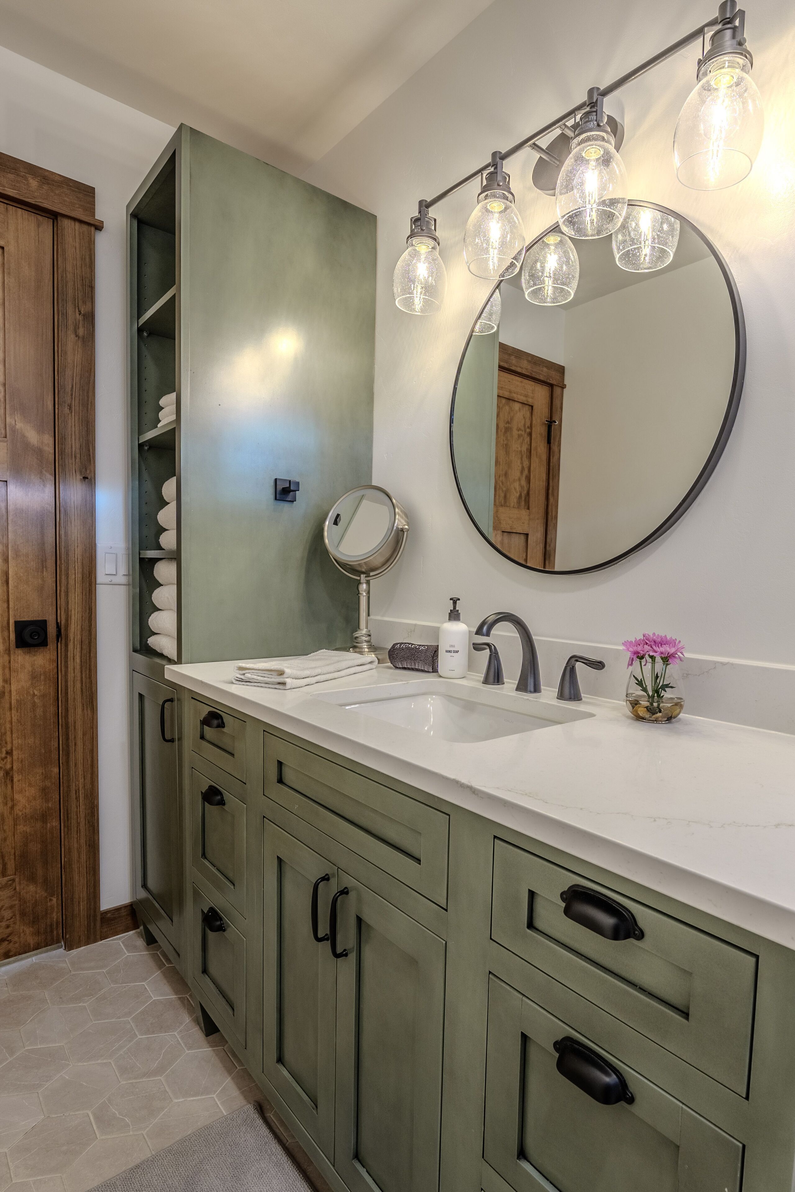 A bathroom with a white sink, a mirror, a towel rack, and a wooden cabinet.