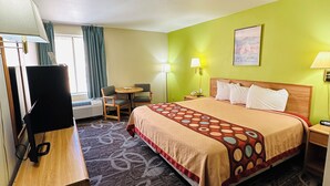 Une chambre d’hôtel avec un lit, un bureau, une chaise et une petite table.