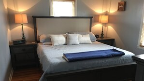 A neatly made bed with a blue blanket, two bedside lamps, and a clock on the nightstand. - SPACIOUS country home, Sleeps 6 adults  (Nicholasville)