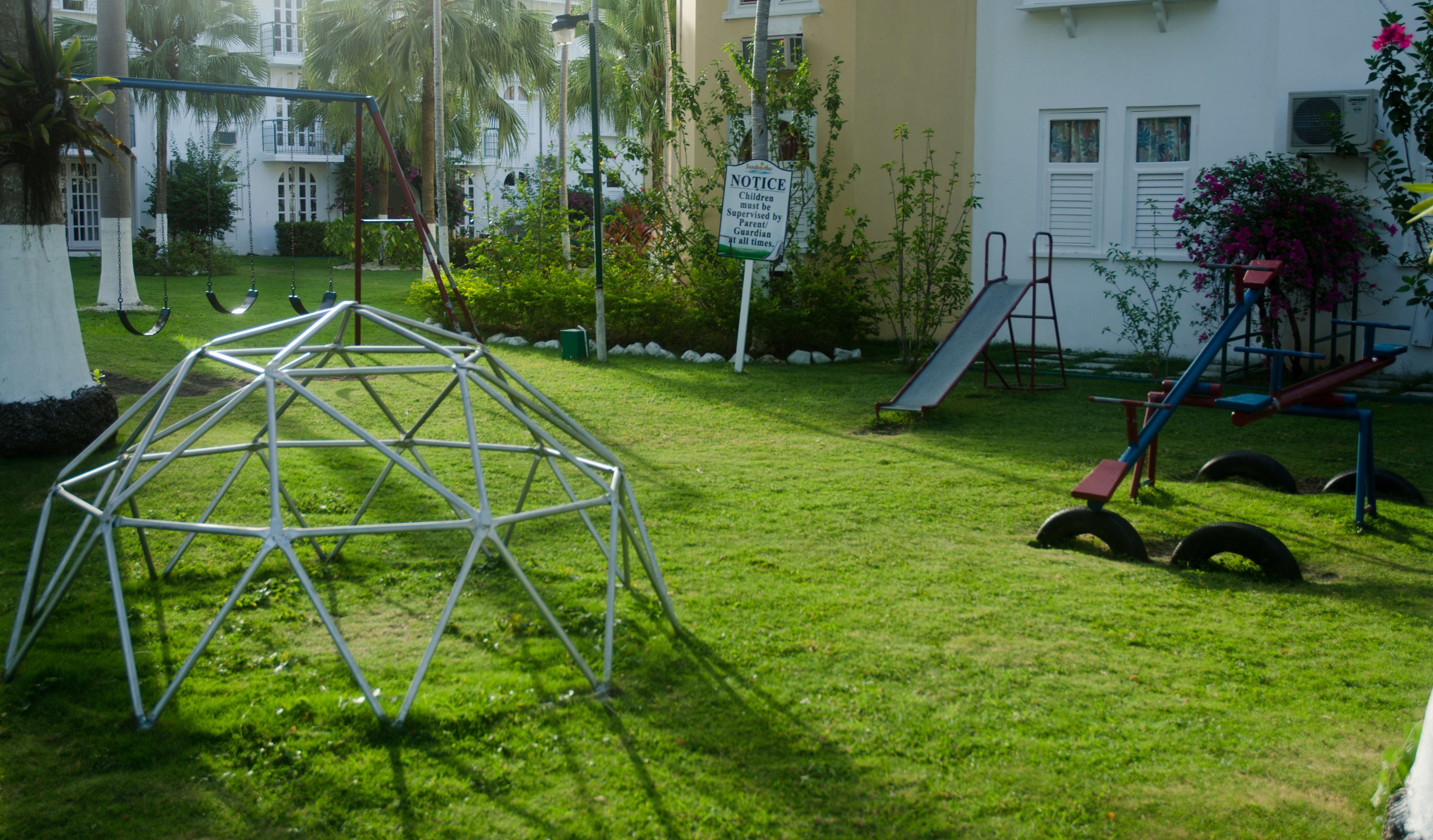 A playground with swings, a slide, and a climbing structure.