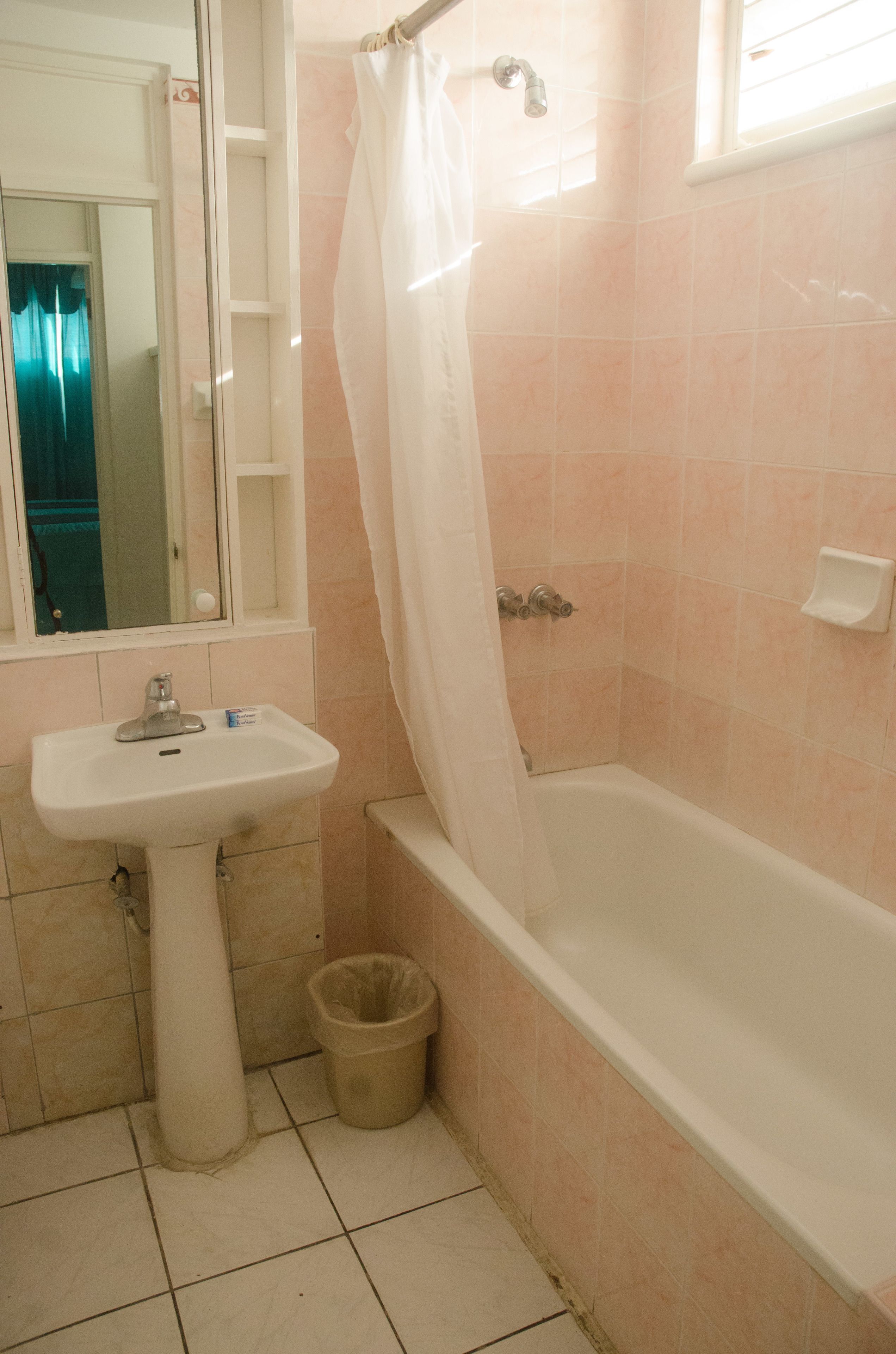 Une salle de bain équipée d’un lavabo, d’une baignoire et d’un rideau de douche.