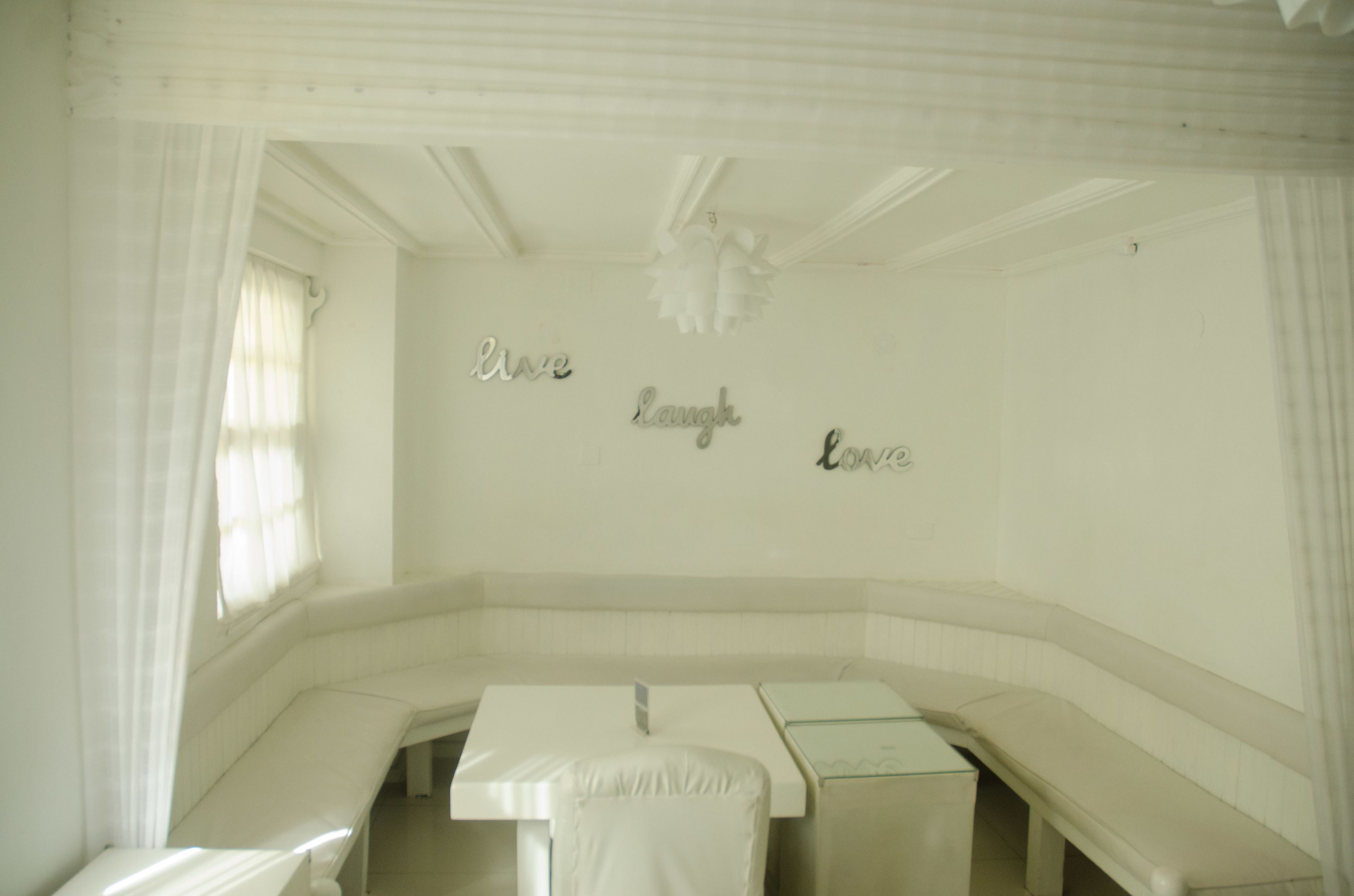 A room with a bench, a table, and a wall with the words "Love Laugh Love" written on it.