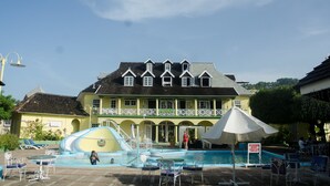 A large building with a swimming pool, a water slide, and outdoor seating areas. - Conch Shell Studio at Sandcastles (Ocho Rios)
