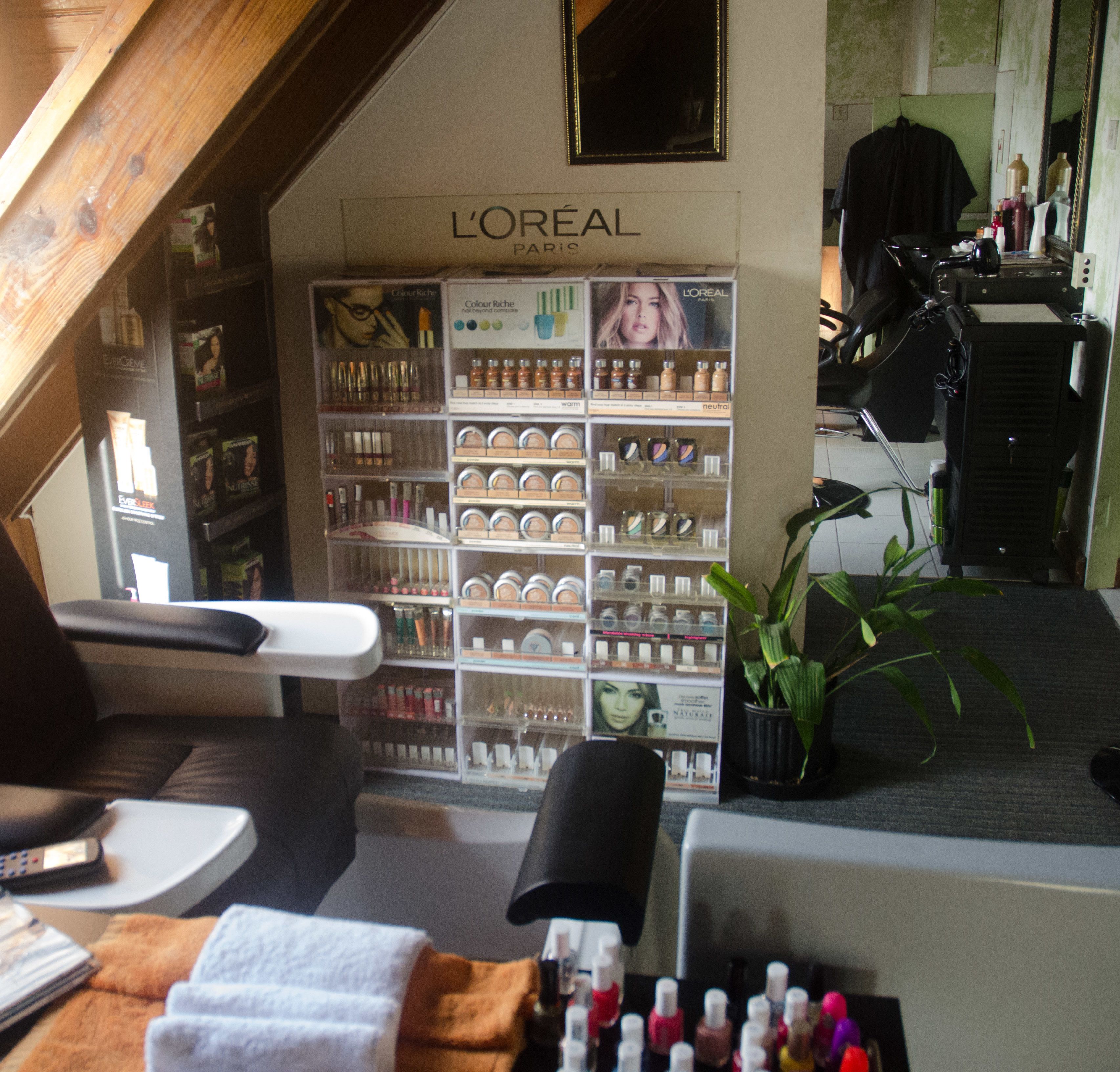 A salon interior with L'Oréal products on display, a mirror, and a plant.