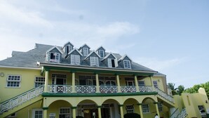 A yellow building with multiple balconies and a staircase.
