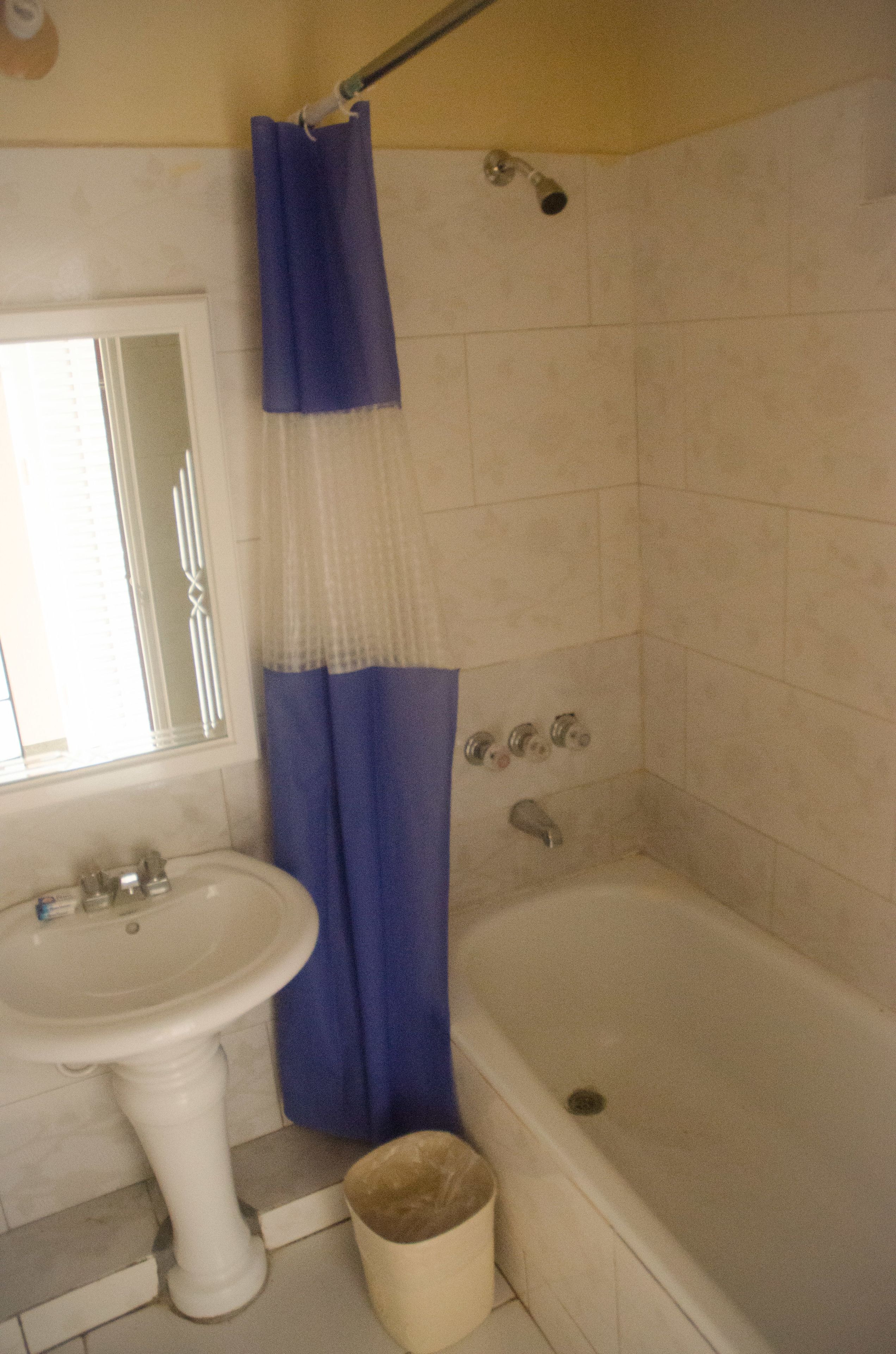 Ein Badezimmer mit einem weißen Waschbecken, einer Badewanne und einer Duschvorhang.