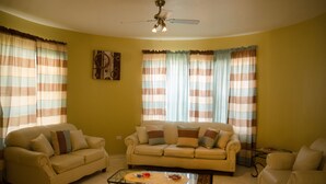 Una sala de estar con dos sofás, una mesa de centro y cortinas.