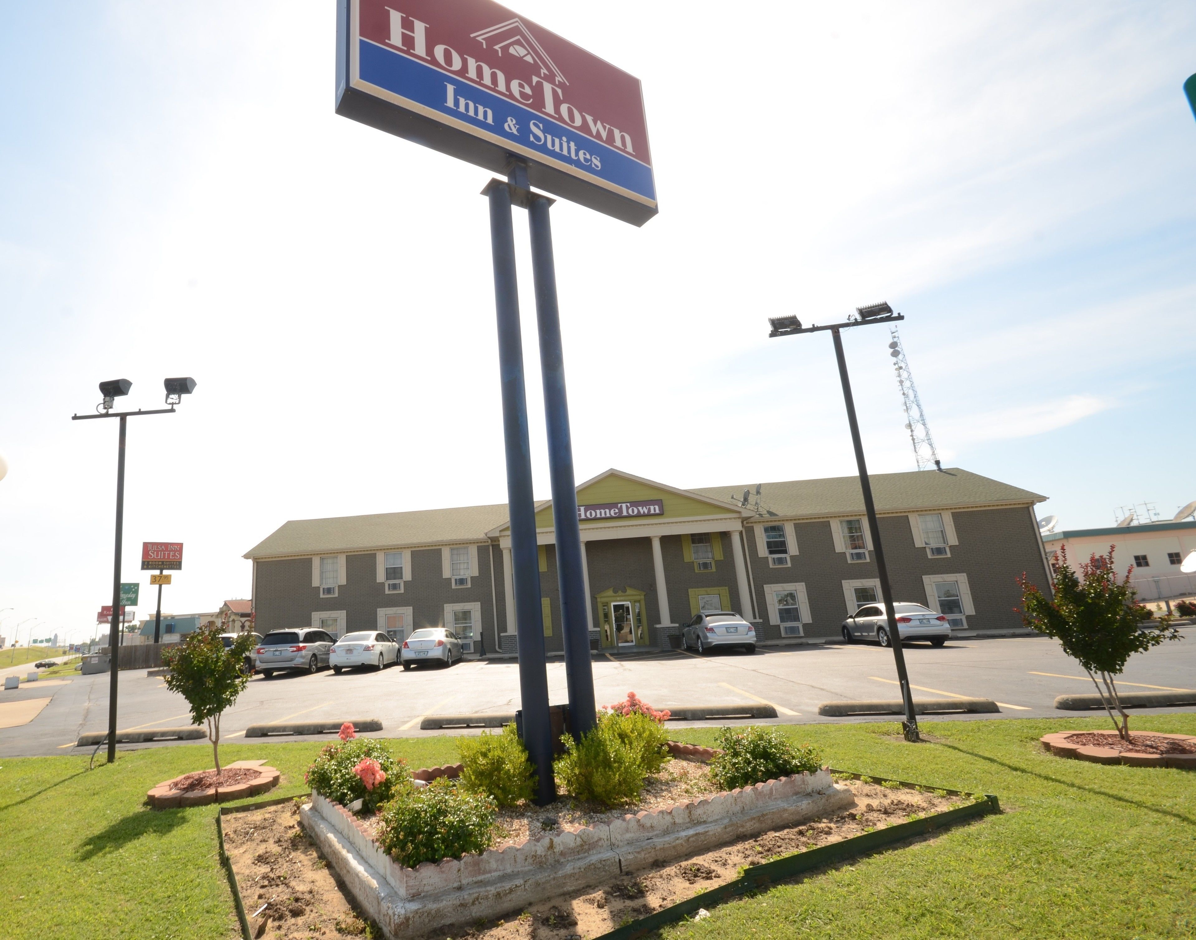 A HomeTown Inn & Suites with a parking lot, a building with a yellow roof, and a signboard.