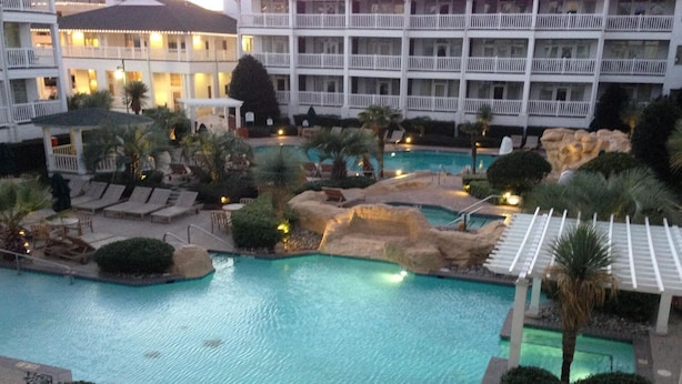 A resort with a swimming pool, lounge chairs, and a building with multiple balconies. - Turtle Cay - Key-West Style 2Bedrm 2.5bath Full Week Oceanview July 10-17 (Virginia Beach)