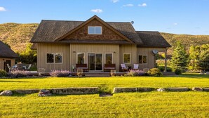 A two-story house with a front porch, large windows, and a well-maintained lawn. - Tranquil Home Along the Yellowstone River (Emigrant)