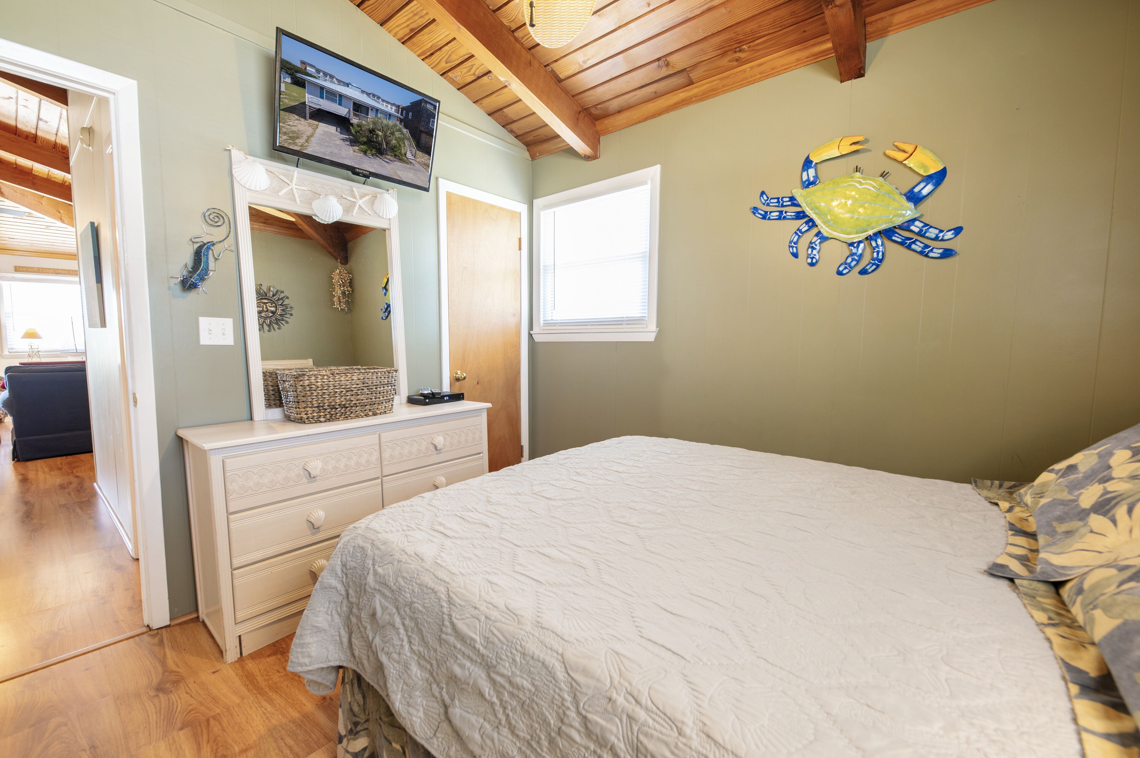 Een slaapkamer met een bed, een kaptafel en een televisie aan de muur.