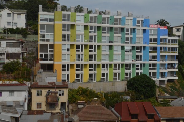 A multi-story building with a distinctive color-blocked facade, featuring balconies and windows.