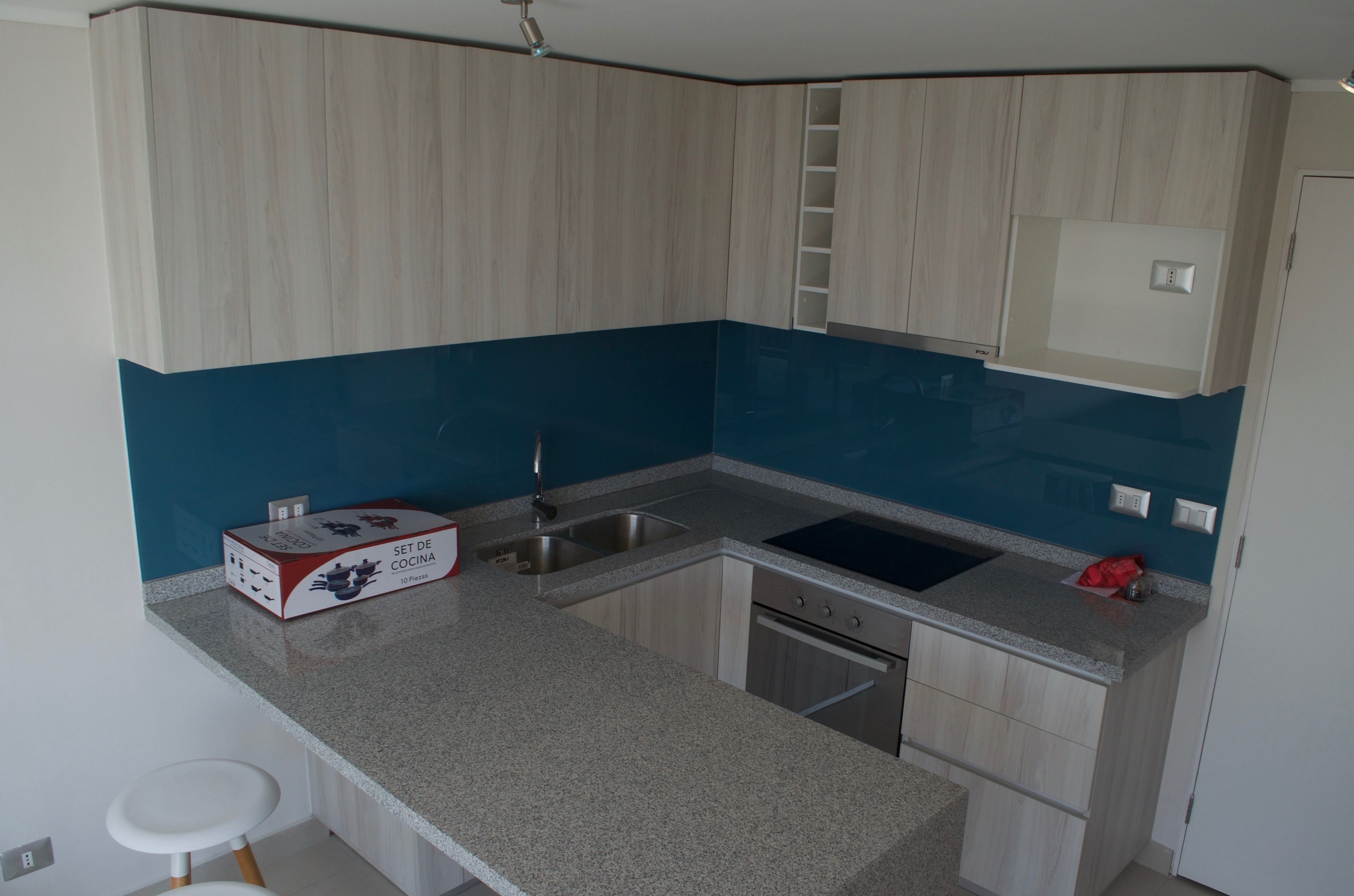 A kitchen with a granite countertop, stainless steel sink, and a dishwasher.