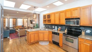 Une cuisine moderne avec des meubles en bois, un four en acier inoxydable et un four à micro-ondes.