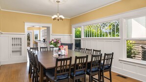 A dining room with a large wooden table, dark chairs, and a chandelier. - Seattle Vacation Home: The Campus (Seattle)
