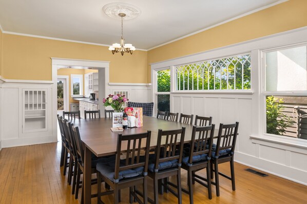A dining room with a large wooden table, dark chairs, and a chandelier. - Seattle Vacation Home: The Campus (Seattle)