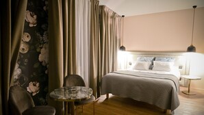 A hotel room with a bed, a round table, two chairs, and a nightstand. - Auberge la Renaissance (Viarmes)