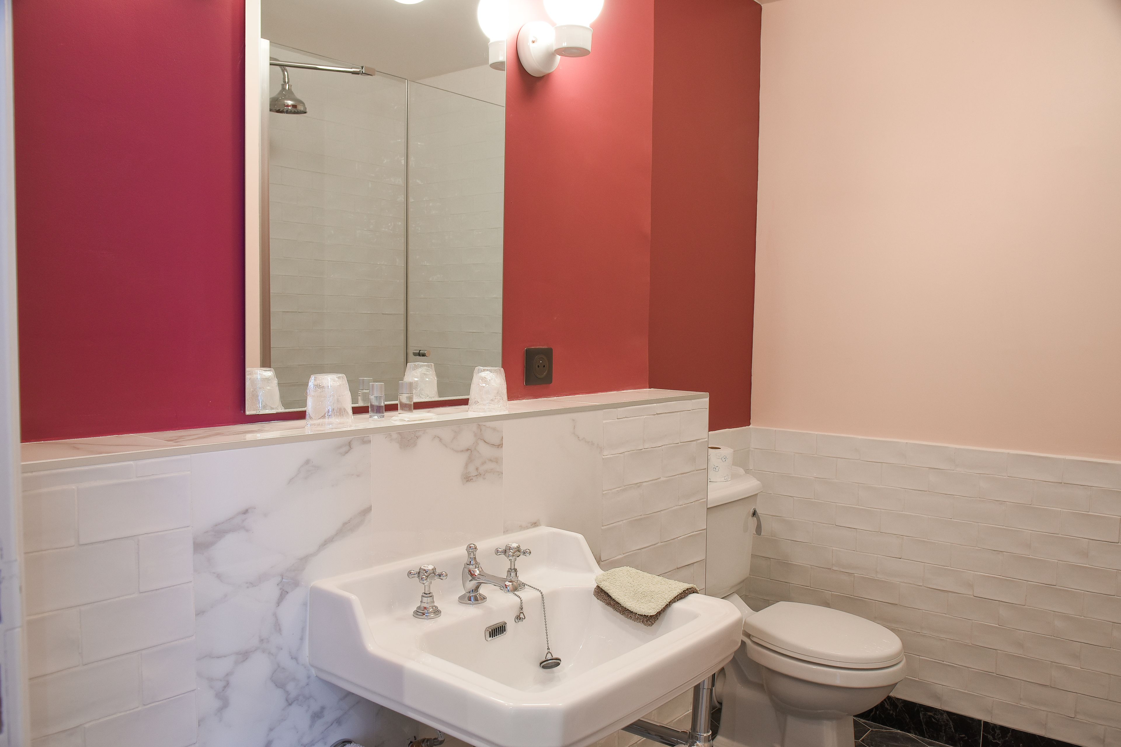 Un bagno con un lavandino bianco, un water e uno specchio.