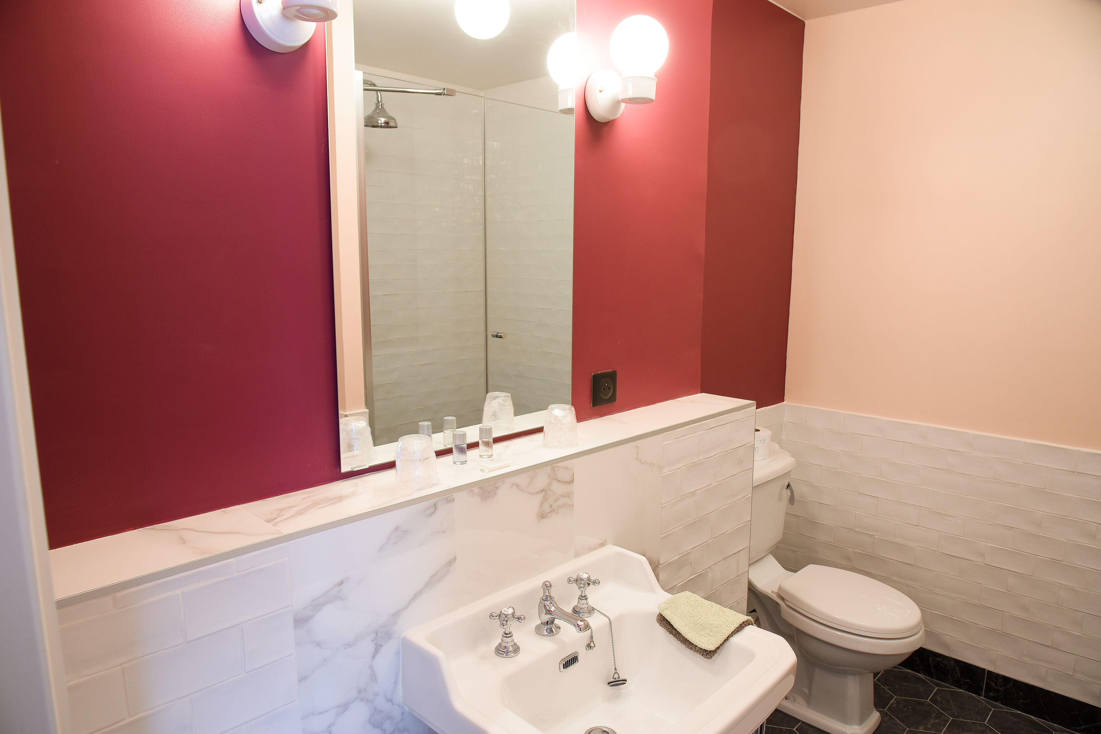 A bathroom with a white sink, a toilet, and a mirror.
