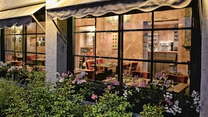 A restaurant with outdoor seating, large windows, and a well-lit interior. - Auberge la Renaissance (Viarmes)