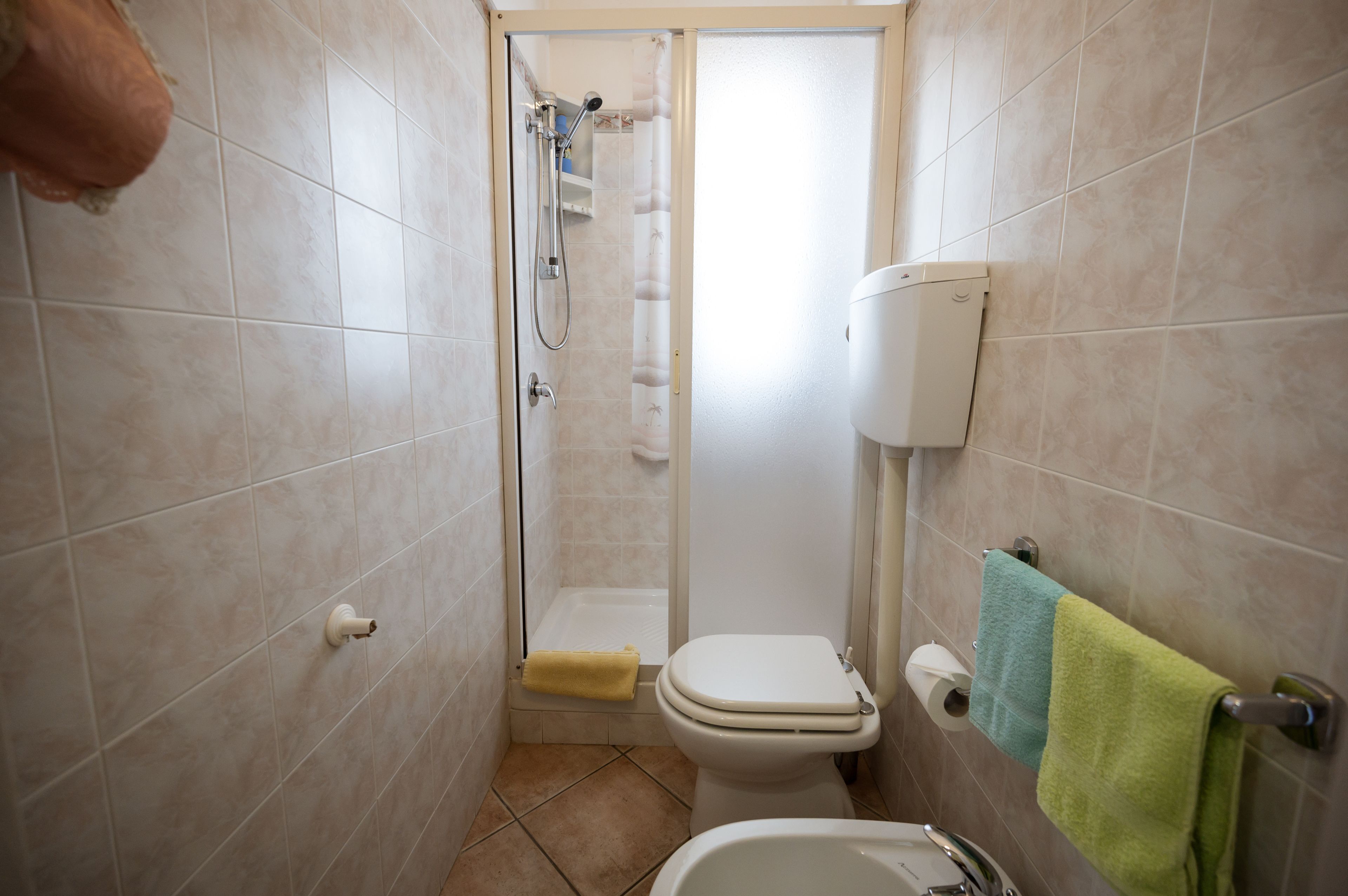 Une petite salle de bain avec des toilettes, une douche et un lavabo.