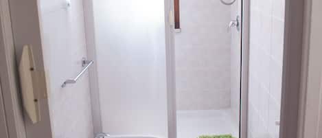 Une salle de bain équipée de toilettes, d’un bidet et d’une douche.