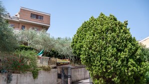 A residential area with a paved driveway leading to a gated entrance. - B&B Panorama (Castelbuono)