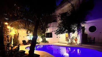 Una piscina al aire libre, sombrillas, tumbonas