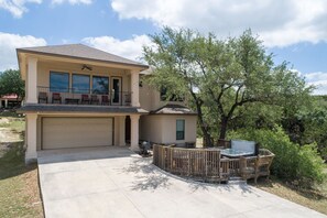 A two-story house with a garage, a balcony, and a hot tub area. - At Canyon Lake CL1233 3 Bedroom Villa by RedAwning (Canyon Lake)