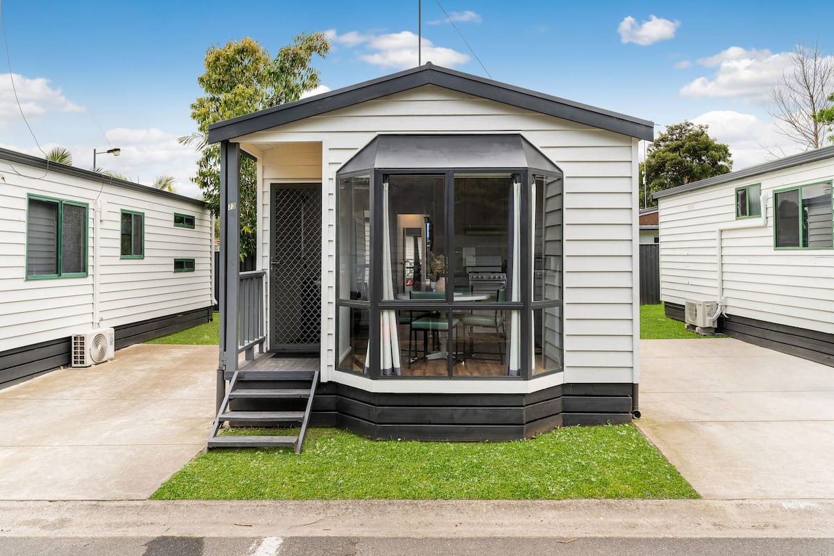 A mobile home with a covered porch and a small deck.