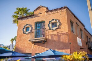 A building with a textured facade, a balcony with a railing, and a window with a decorative frame. - Downtown Sarasota Suite in Historic District Walk to Opera, SelbyGardens, Dining (Sarasota)